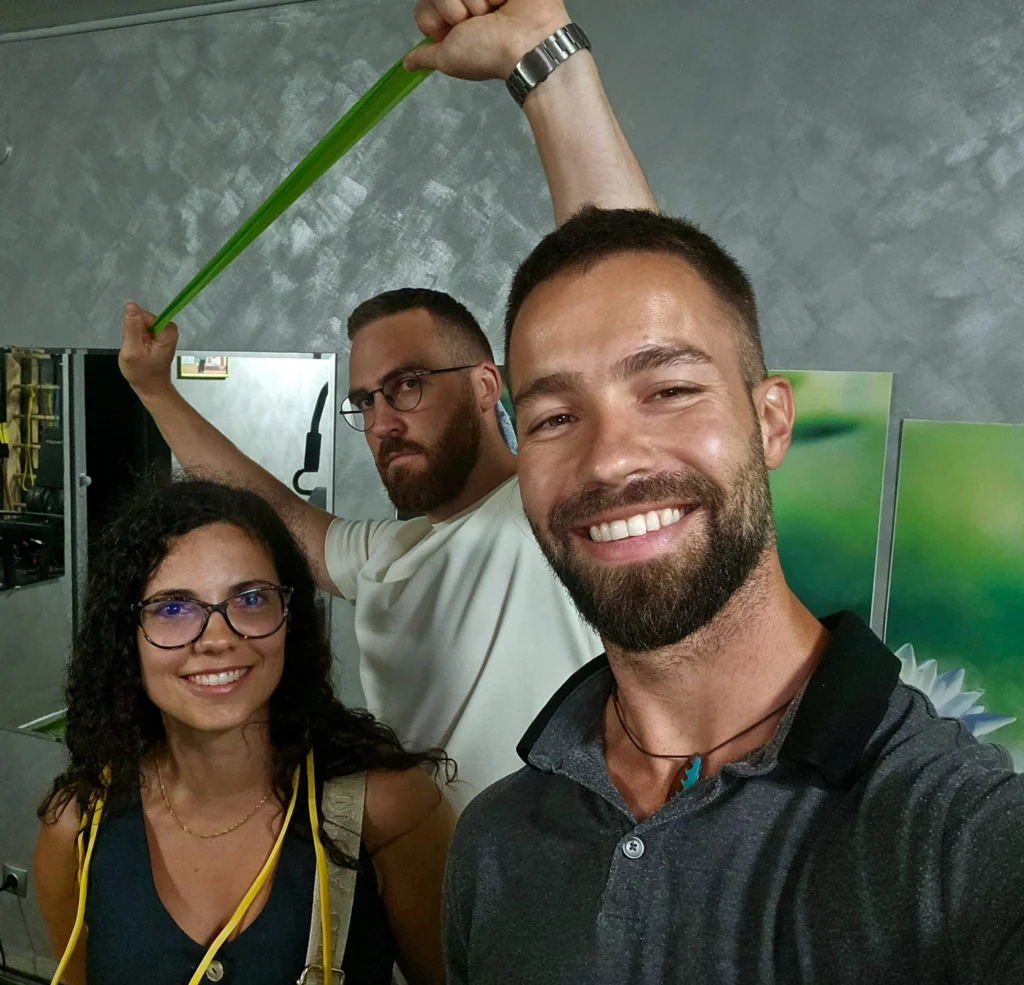 Kaloyan Zarkov with two smiling patients and a resistance band in the exercise room