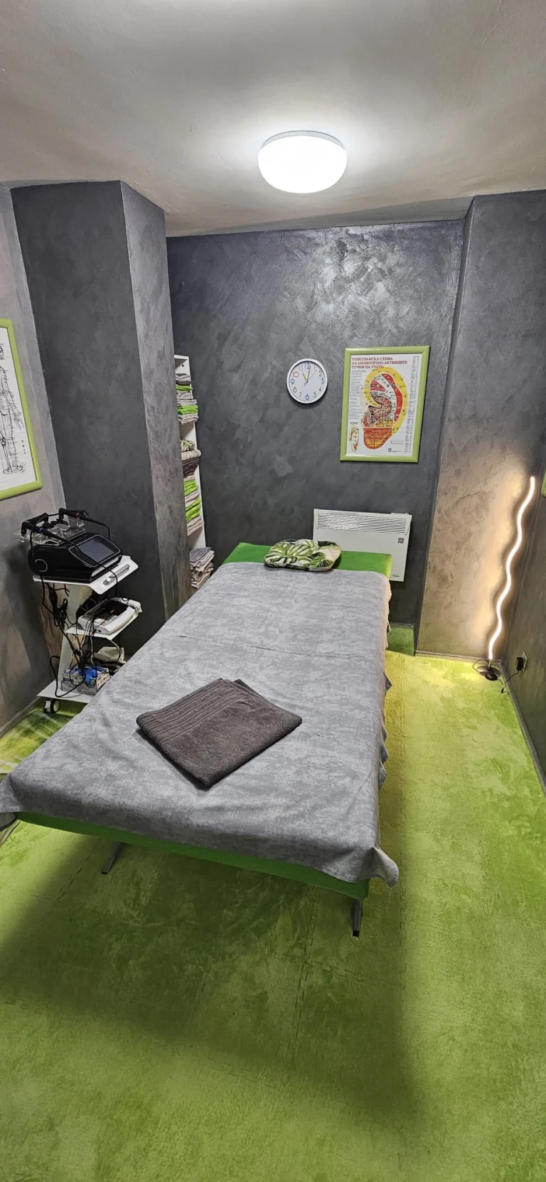 Treatment room with a therapy table and a physiotherapy device