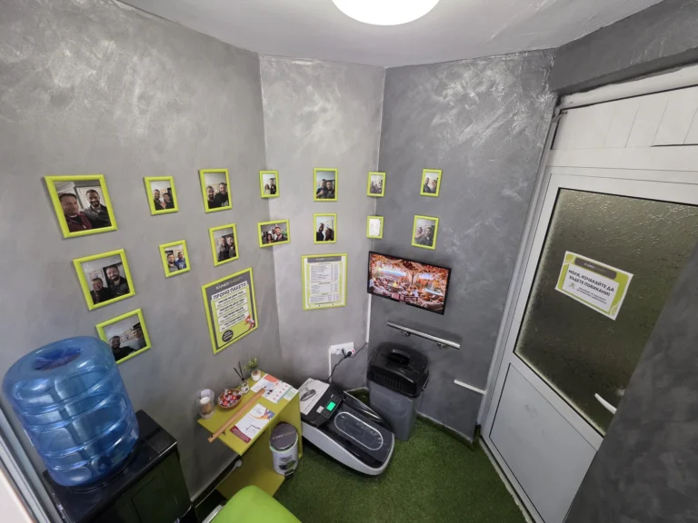 Waiting area with framed photos, a TV and a water dispenser